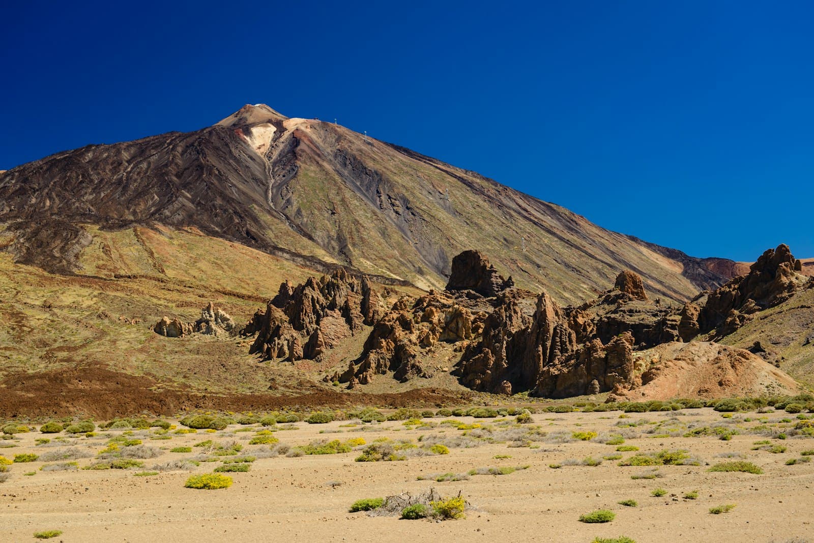 A green mountainside on Tenerife rising into clear sky.